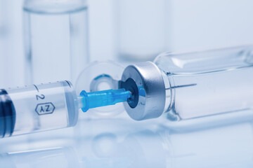 Closeup of glass medicine vials with liquid and a syringe