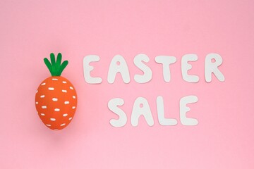 Colourful eggs with funny carrot and lettering Easter sale on pink background. Easter sale banner with easter decorated eggs. Top view, flatlay creative concept for postcard, poster, magazine