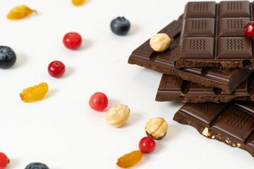 Handmade chocolate bars with fruits, berries and nuts on a white background.