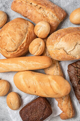 Various bakery products on grunge gray background. Top view, selective focus. Fresh bread.