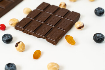 Handmade chocolate bars with fruits, berries and nuts on a white background.
