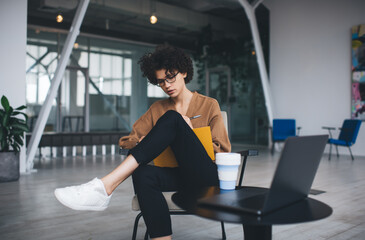 Millennial woman writing in notebook in office