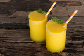 Mango juice fruit smoothies yogurt drink yellow healthy delicious taste in a glass slush for weight loss on wooden background.