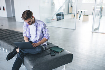 Millennial businessman working on laptop in office