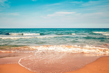 waves on mediterranean sandy beach with blue sky in Alicante, Spain