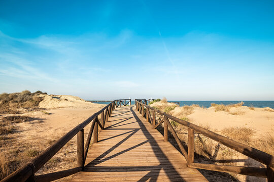 wooden footbridge over sand dunes leads out to the Guardamar beach in Alicante, Spain