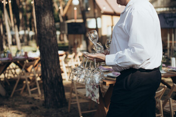 catering, the waiter carries clean glasses