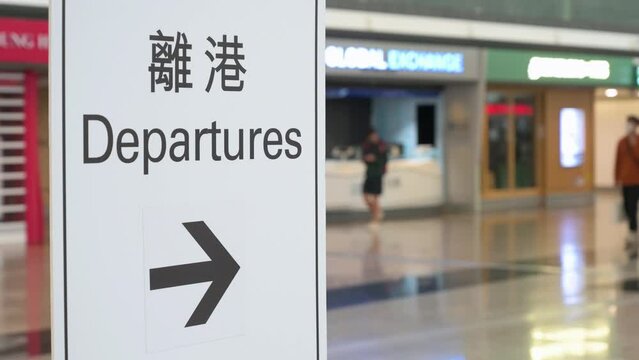 A sign with the word "Departures" indicates the location of the departure hall at Chek Lap Kok International Airport in Hong Kong, China.