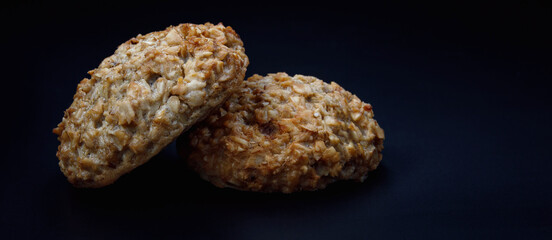 Fresh handmade oatmeal cookies on a dark background.