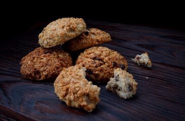 Oatmeal cookies lie on a wooden surface. Rustic oatmeal cookies. Whole and crushed cookies.