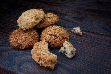 Whole and crushed oatmeal cookies lie on a wooden surface. Rustic oatmeal cookies.