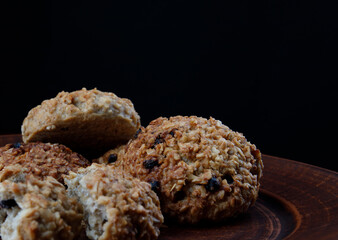 Whole and crushed oatmeal cookies lie on a clay plate. Rustic oatmeal cookies.