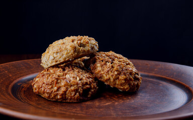 Oatmeal cookies lie on a clay plate. Rustic oatmeal cookies.