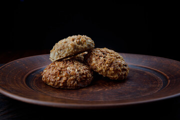 Oatmeal cookies lie on a clay plate. Rustic oatmeal cookies.