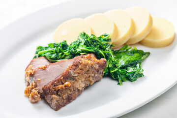 pork meat with garlic served with spinach and potato dumplings