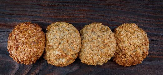 Oatmeal cookies laid out in a row on a wooden board top view. Rustic oatmeal cookies.