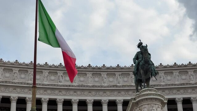 Slow motion shot of waving italian flag beside sculpture of Victor Emmanuel II Monument in Rome