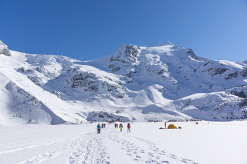 Hikers leaving tracks on snowy valley landscape