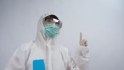 Doctor in PPE suit wearing white medical rubber gloves and clear goggles and green N95 face mask to protect pandemic Coronavirus. gesture make hand sign. Represent victory win over virus. Isolated