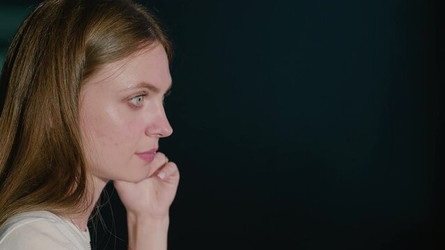 Close-up of a woman sidewise looking at the monitor. Person at work in an office