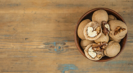 Fototapeta na wymiar bowl full of delicious and fresh walnuts on an old wooden table
