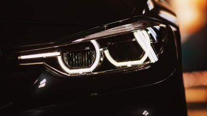 Car LED headlights in night. New modern car headlamp, close up.