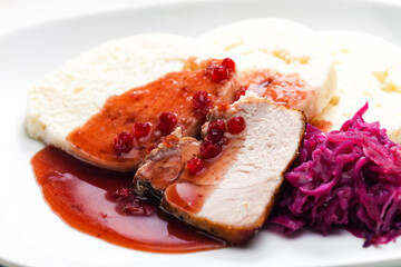 pork meat with red cabbage, cranberry sauce and dumplings