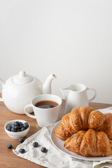 Fototapeta na wymiar croissants with blueberries and tea on a wooden table