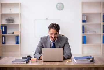 Young male employee sitting in the office