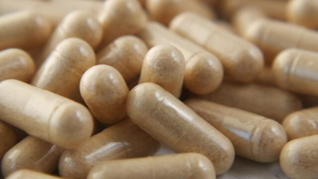 herbal medicine capsule spilling on table close up 