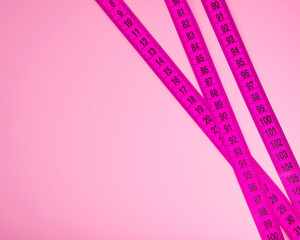 Pink tape measure diet concept background with space for text