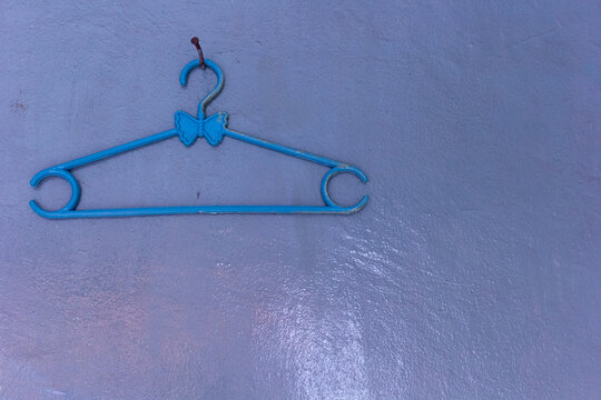 Close-up shot of a blue hanger hanging at the white wall. Jakarta, Indonesia