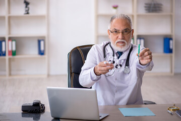 Old male doctor working in the clinic