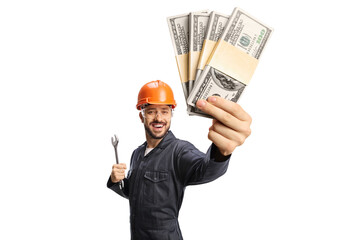 Worker in a uniform with helmet holding a wrench and money
