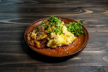 Mashed potatoes or boiled puree with fried egg and microgreens for breakfast. Close up view of fresh breakfast on rough wooden background. Great combination of flavours and spicy. Selective Focus
