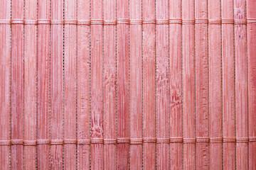 Closeup shot of the pink vertical parallel lines made of bamboo texture for backgrounds