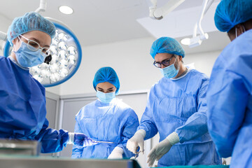 Portrait of team of multiethnic surgeons at work in a operation theatre. Several doctors...