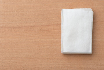 Stacked wrapped wet wipes on wooden table