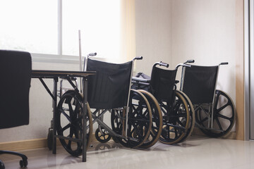 Three wheelchairs line up by the window to pick up patients in the hospital.