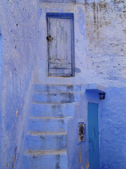 Calle con escaleras en Chaouen, Marruecos, turismo en pueblo azul encalado - 497559901