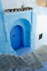 Calle con escaleras en Chaouen, Marruecos, turismo en pueblo azul encalado - 497559971