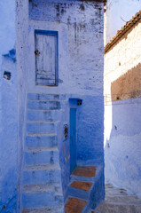 Fototapeta na wymiar Calle con escaleras en Chaouen, Marruecos, turismo en pueblo azul encalado