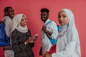 A group of African Muslim students with backpacks posing on a pink background. the concept of school education.