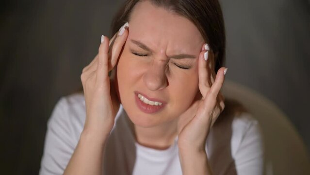 Young woman holding head. Female with headache. Person feel pain, touch face. Migraine or stressed worried girl.