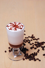 Glass of white coffee with bailey and beans isolated on wooden table