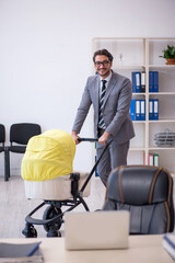 Young male employee looking after new born at workplace