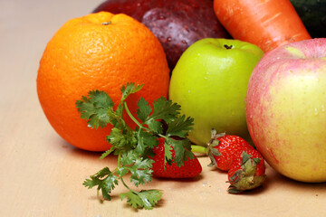 Naklejka na ściany i meble closeup of fresh fruit apple, orange, strawberry, grape; carrot; avocado isolated on wooden table