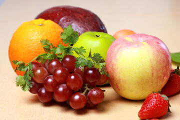 Naklejka na ściany i meble closeup of fresh fruit apple, orange, strawberry, grape; carrot; avocado isolated on wooden table