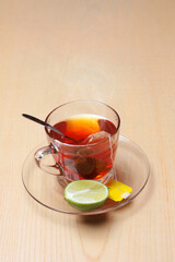 Cup of tea with tea bag, lemon on wooden table for dessert