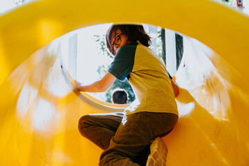 Portrait of Caucasian boy sliding in playground in Argentina